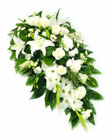 A photo of the White Single Ended Spray arrangement, featuring grand lilies surrounded by abundant white roses, chrysanthemums, and lush foliage. An arrangement that exudes serenity and reverence.